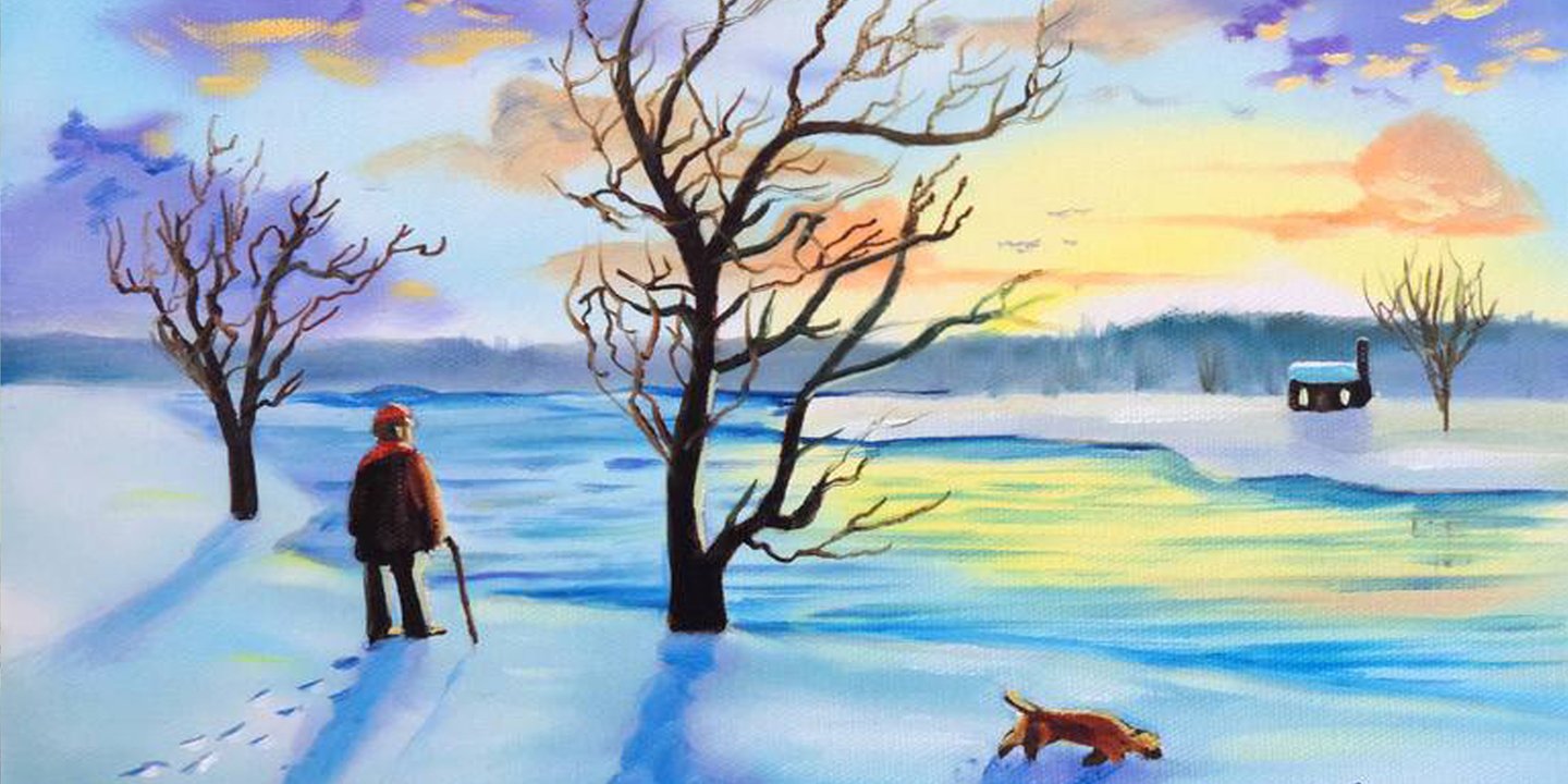 A man walks his dog in the snow by a river