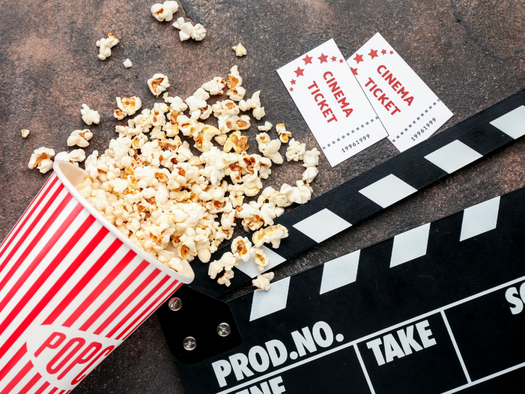 Valentine's Day Date Ideas - Bridget Jones movie. The picture shows two cinema tickets, an action sign, and popcorn over a table